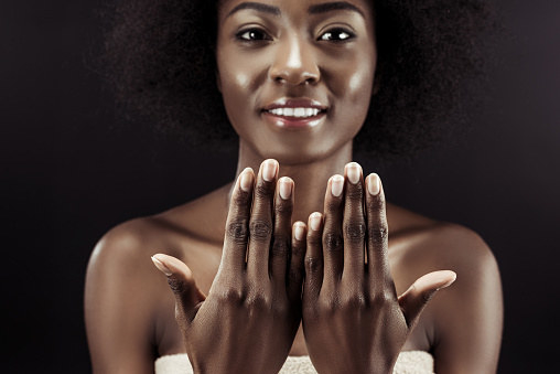 A woman holds up both beautifully manicured hands.