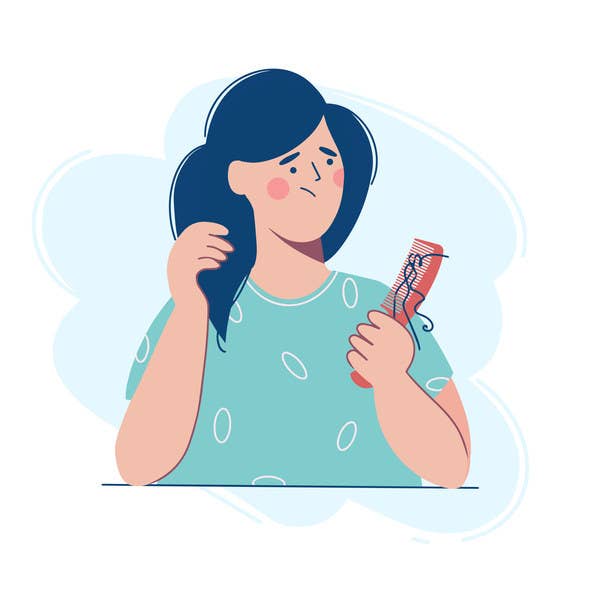 A woman is holding a comb with a lock of hair, she is upset because of hair loss.
