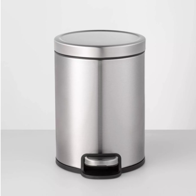 A small, round step trash can that can be placed anywhere in the kitchen