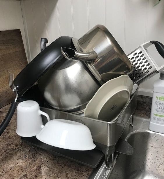 Reviewer&#x27;s picture of the drying rack holding many dishes, pots, and mugs 