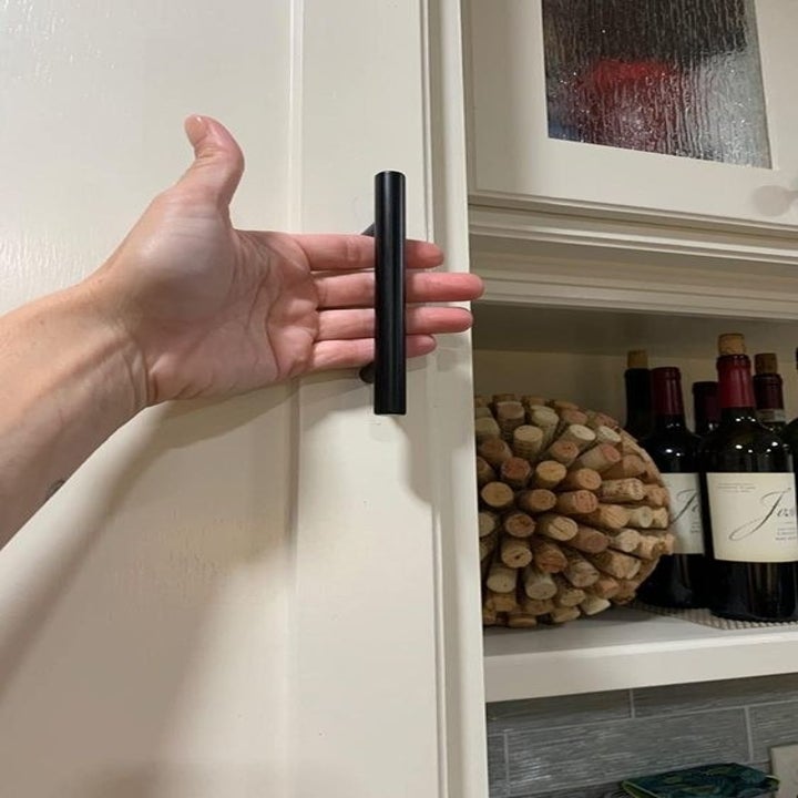 Reviewer's closeup of the sleek black bar handle for their cabinet 