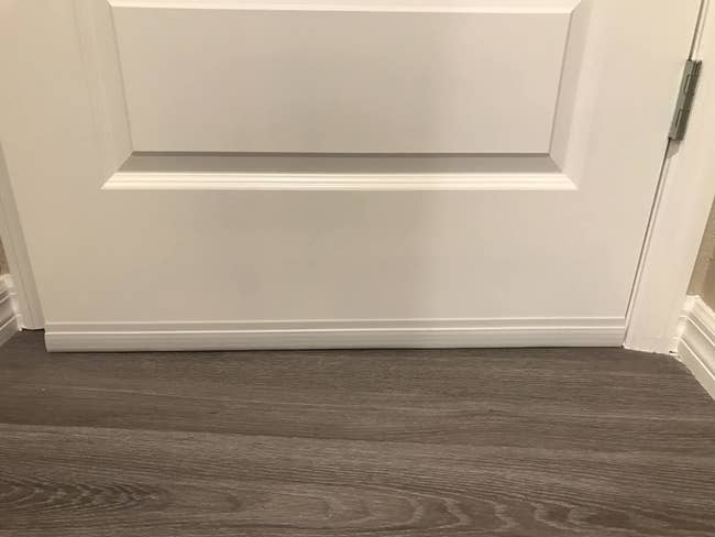 close up of the aforesaid doorway but with a achromatic suptike doorway draught stopper installed astatine the bottommost gap