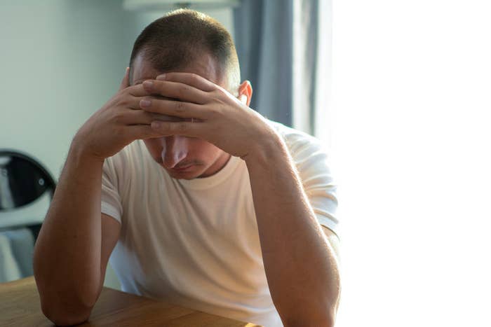 man holding his head in his hands