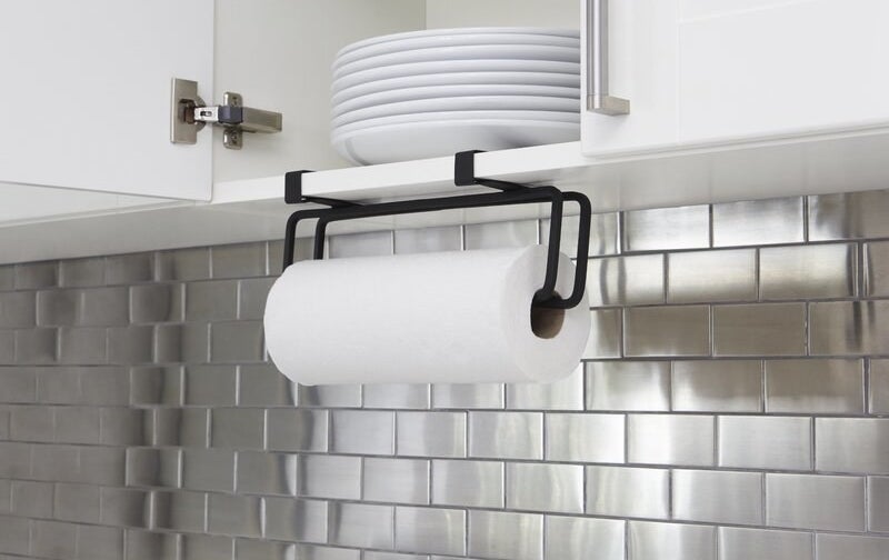 The paper towel holder attached to a kitchen shelf 