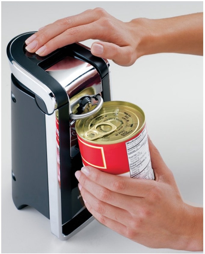 A model opening up a can of soup using the Hamilton Beach, black and silver electric can opener