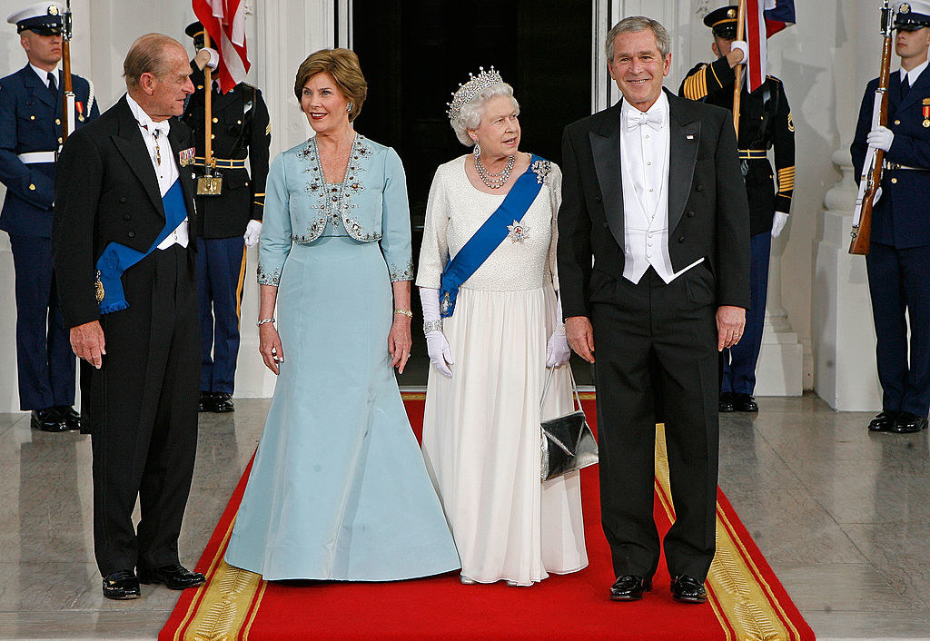 The Bushes and the Queen and Prince Philip stand on a red carpet wearing formal outfits
