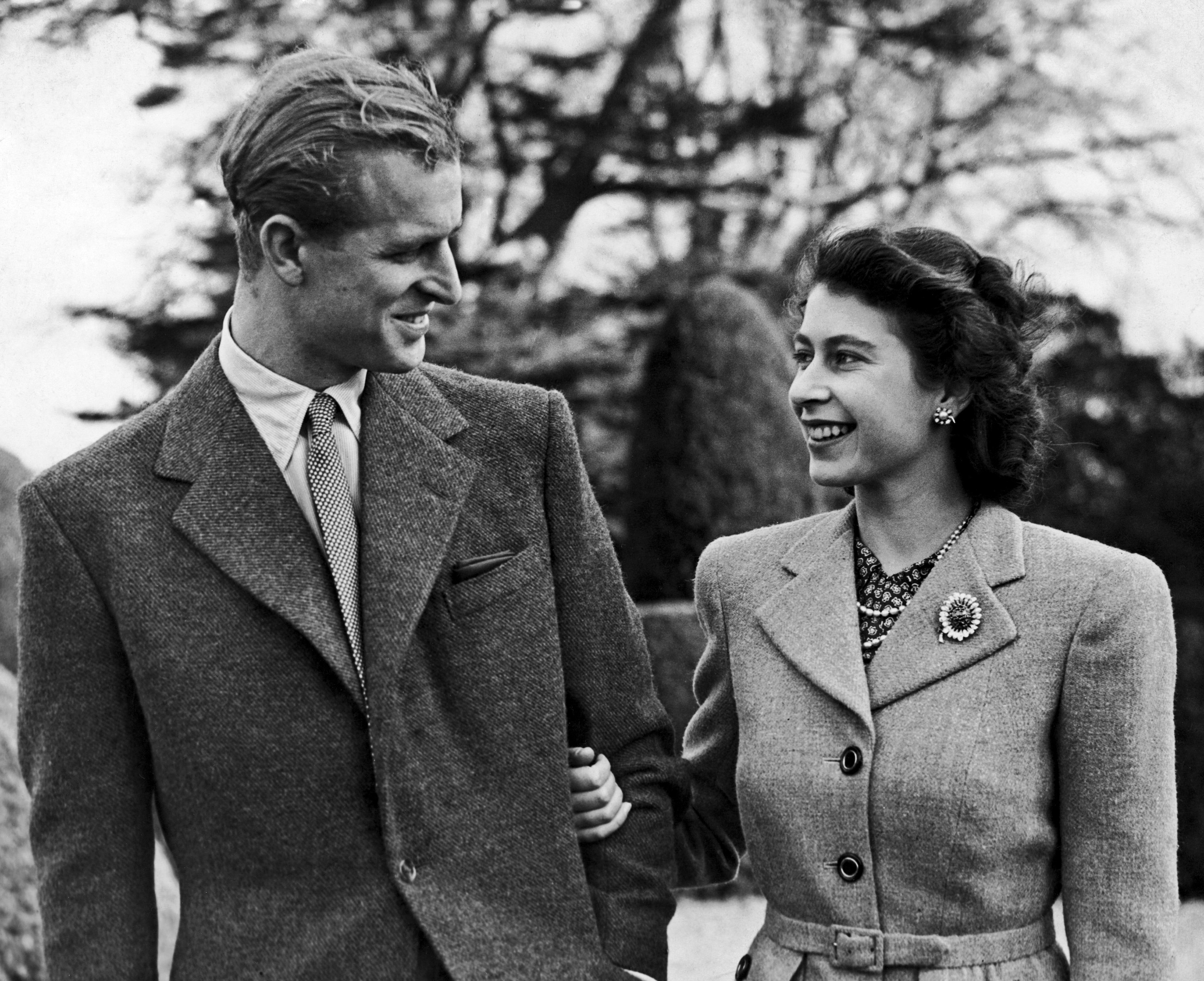 A young Prince Philip and Queen Elizabeth walk arm in arm
