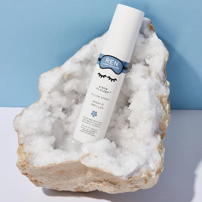 A bottle of pillow spray nestled in a mineral rock