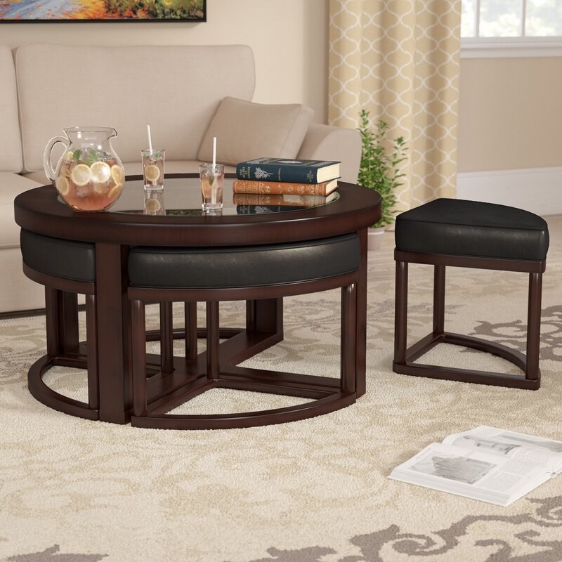 The round leather and wooden coffee table with stools that can fit directly underneath 