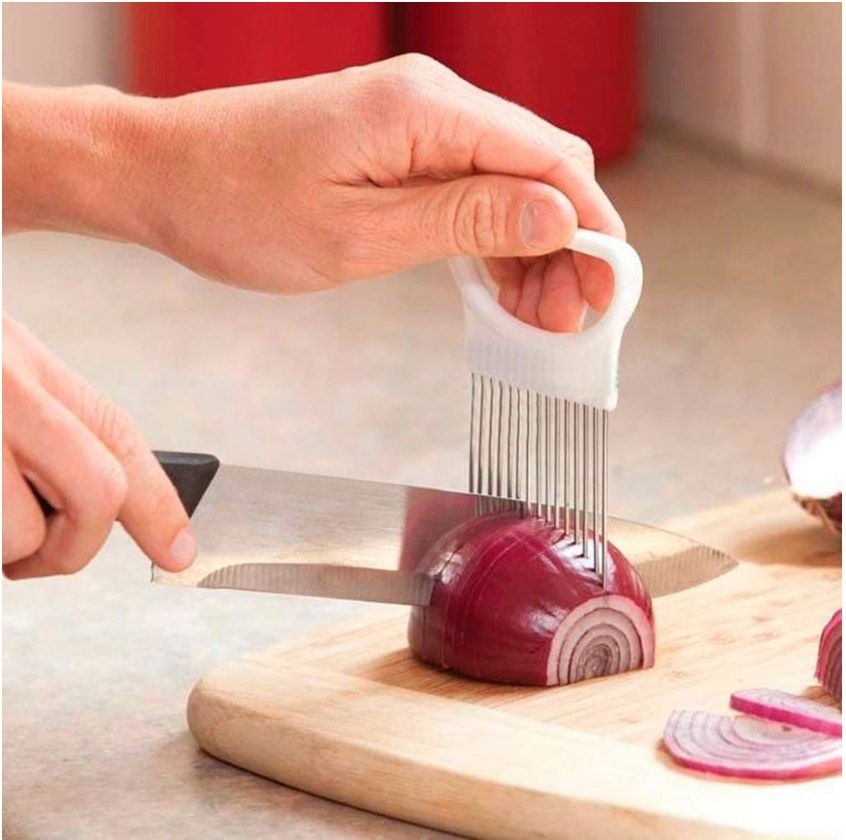A stainless steel vegetable holder with the prongs inside an onion to create a perfectly, even cut