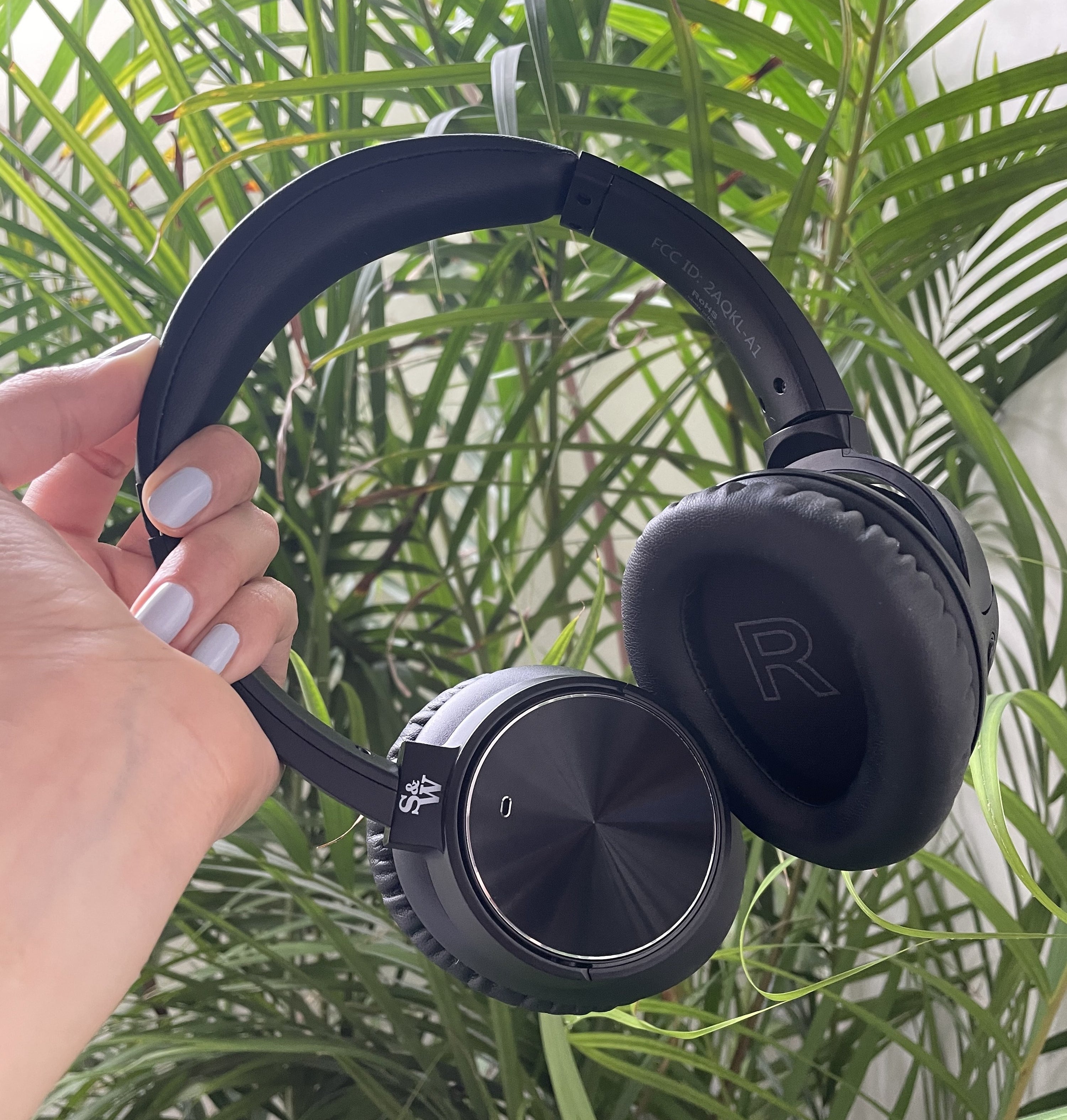 Brittany holding up a pair of Strauss and Wagner headphones