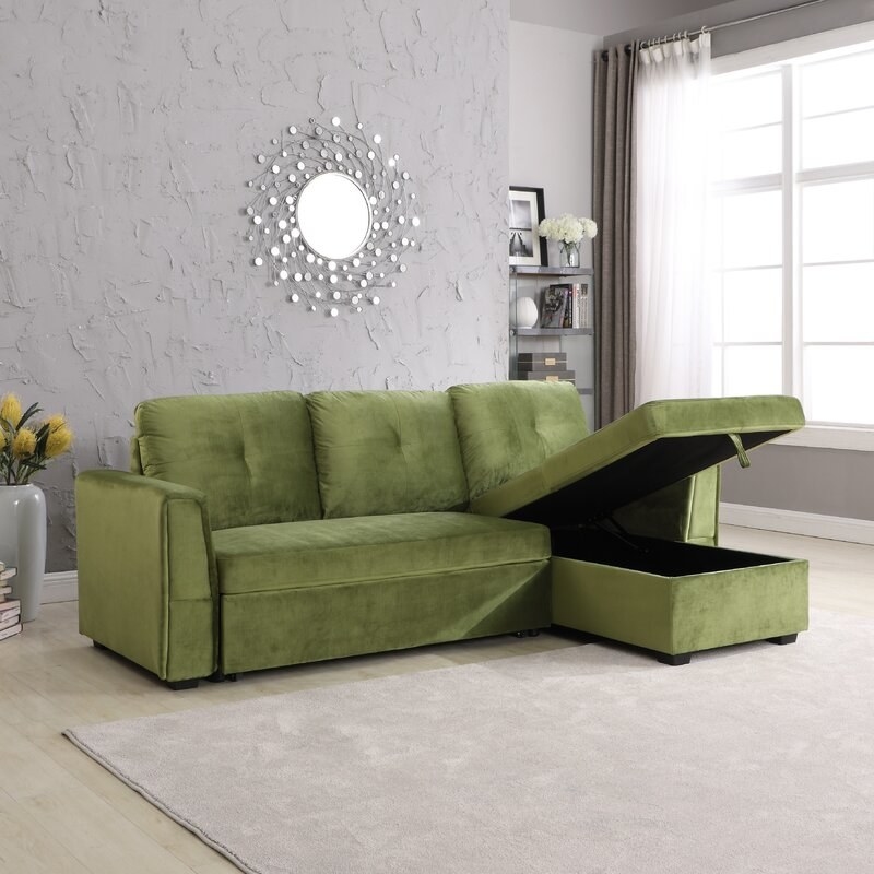 The velvet couch in green that has hidden pull-out storage