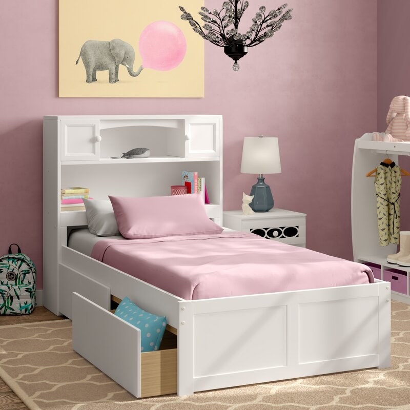 The bed frame in white with shelved head board and two pull-out drawers