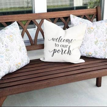 same pillow cover on a pillow placed on top of a wooden porch bench