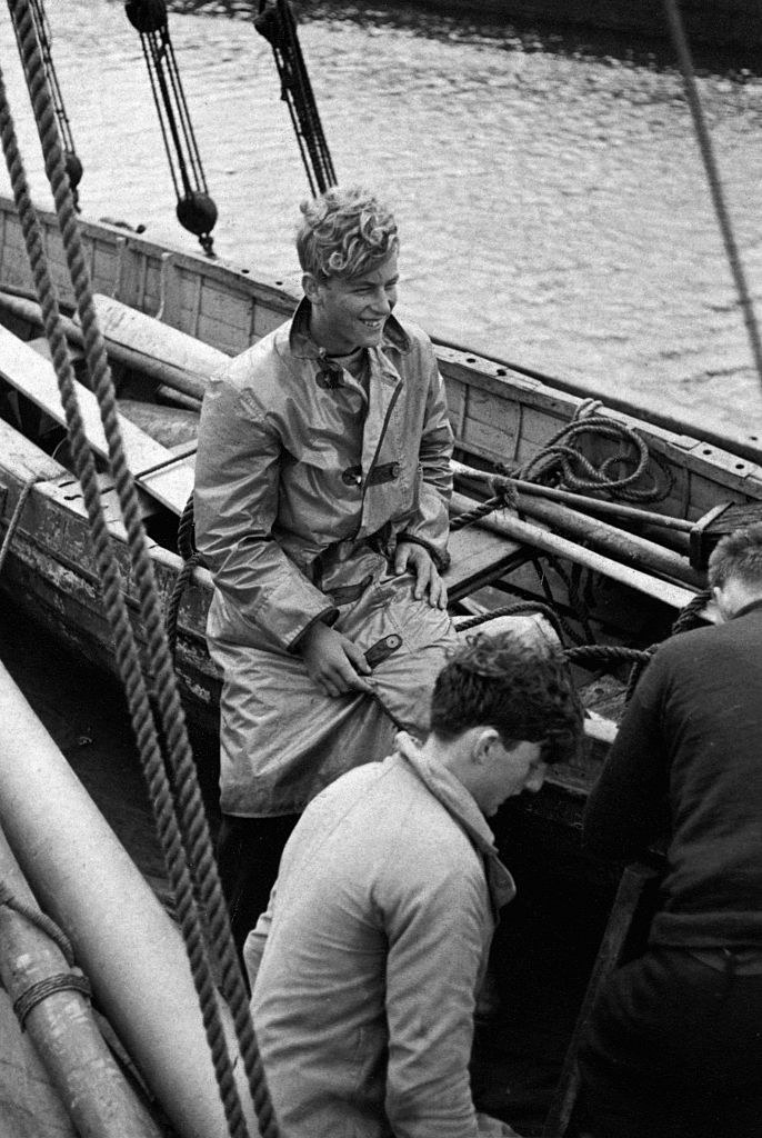 A young Prince Philip smiling on a boat