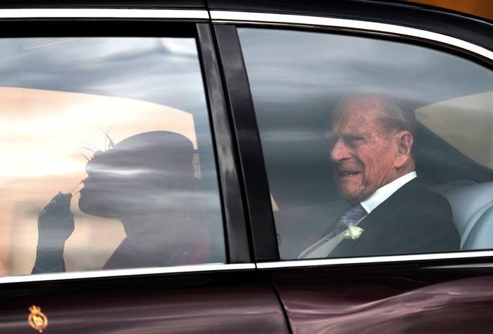 Prince Philip and Queen Elizabeth riding in the back of the car