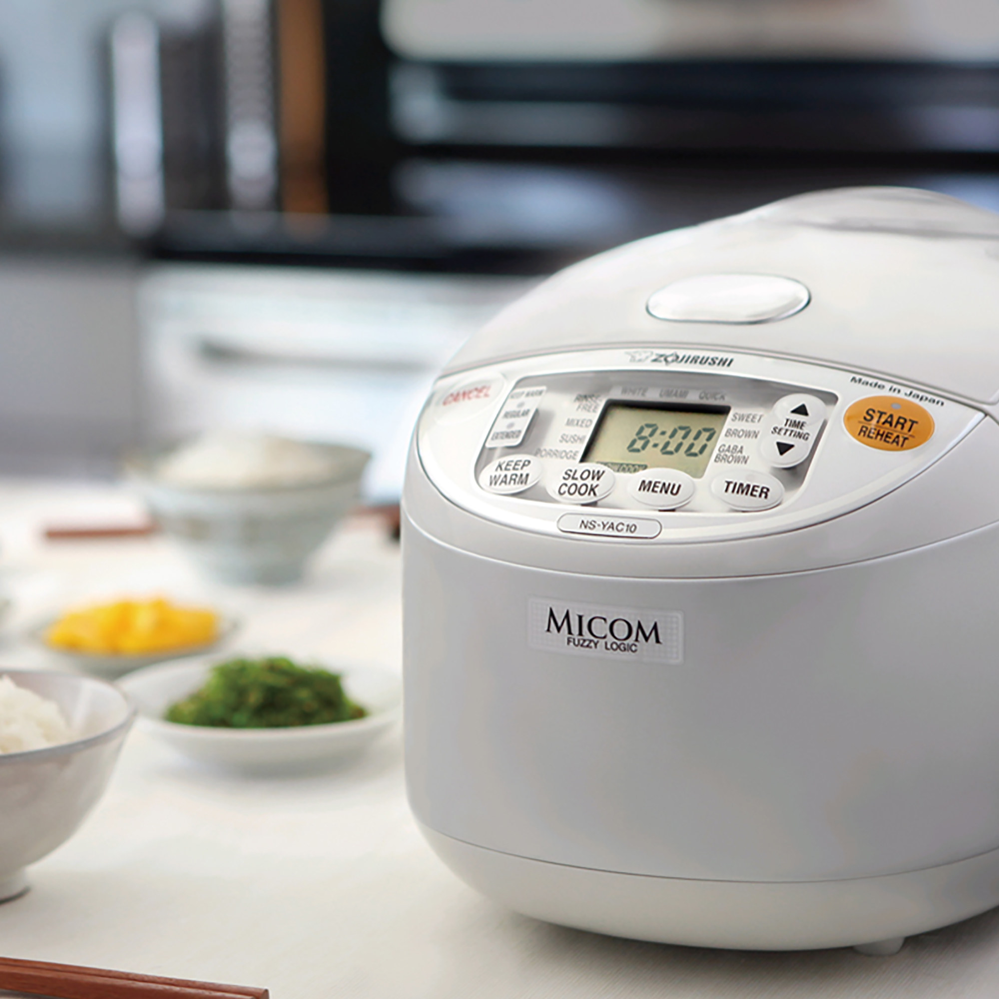 the white rice cooker which has a small digital screen and a handful of buttons