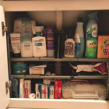 a reviewer photo of the same under-sink cabinet organized with the adjustable shelf 