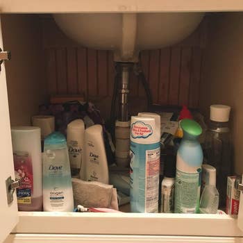 a reviewer image of a clutter under-sink cabinet 