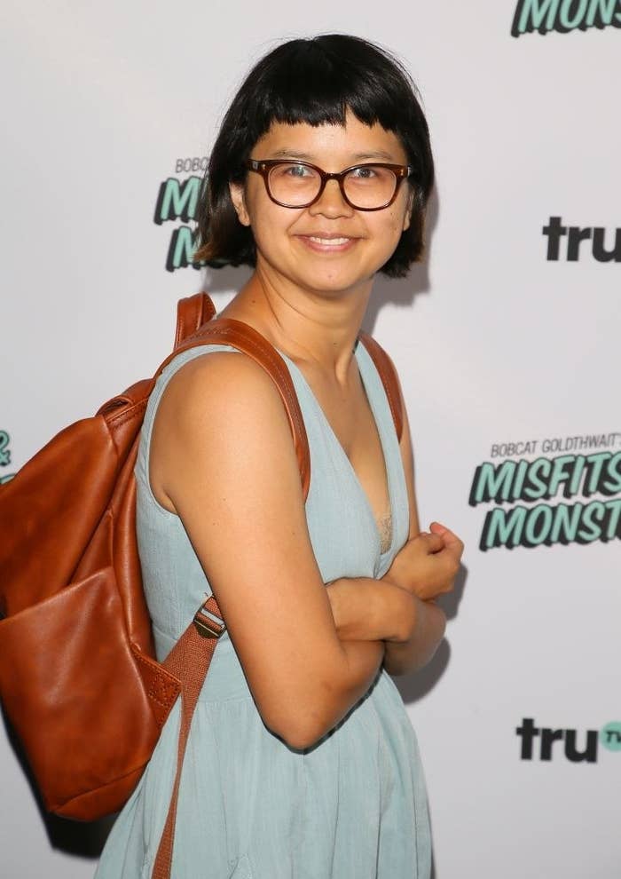 Charlyne posing on a red carpet while wearing a leather-style backpack