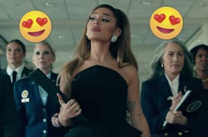 Ariana Grande walks down a hall flanked by a female entourage during the music video of