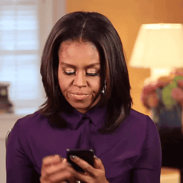 Michelle Obama scrolling through her phone then looking up