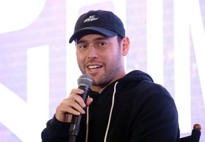 Scooter Braun wearing a cap and speaking into a microphone