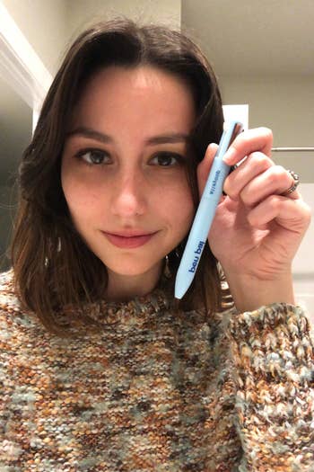 editor holding the same 4-in-1 makeup pen in hand