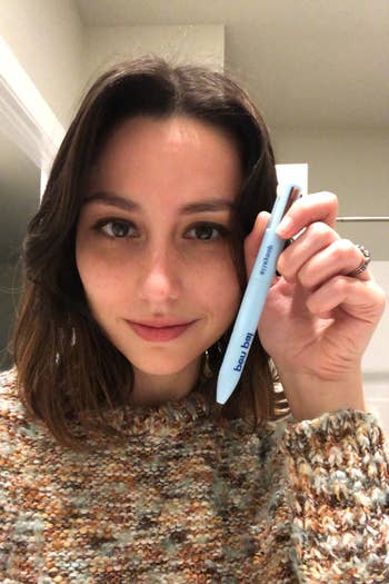 editor holding the same 4-in-1 makeup pen in hand
