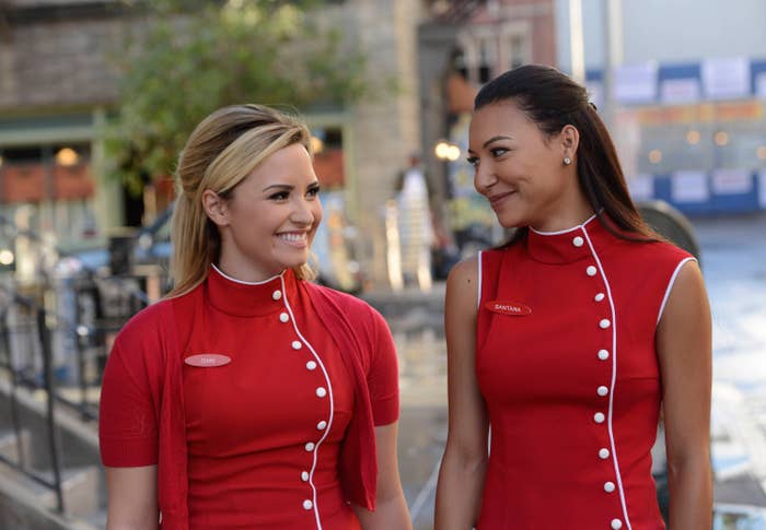 Demi Lovato and Naya Rivera look at each other in the TV show Glee