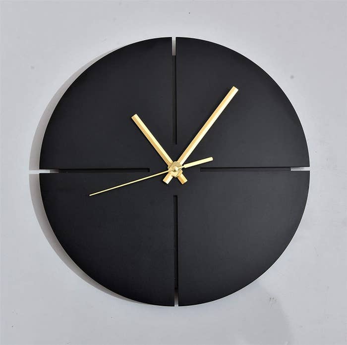 A black and gold clock on the wall 