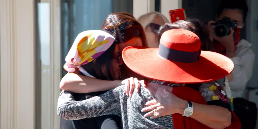 Four adults join together in a group hug