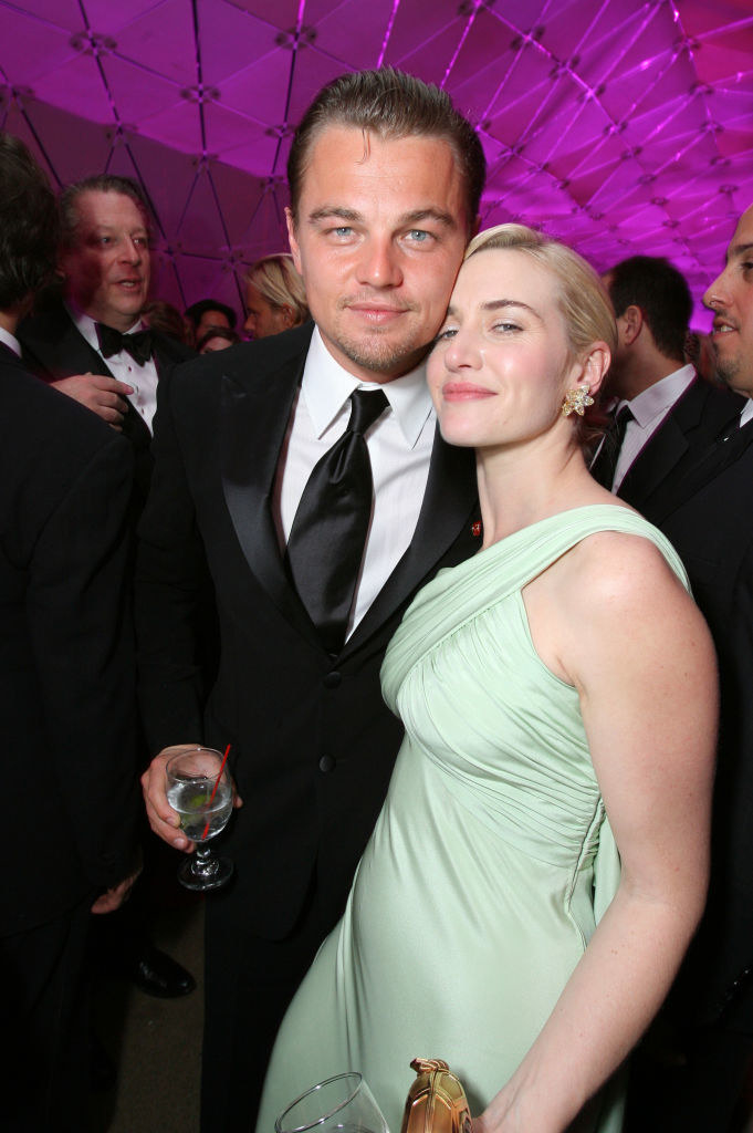 Leo and Kate looking into the camera and touching cheeks