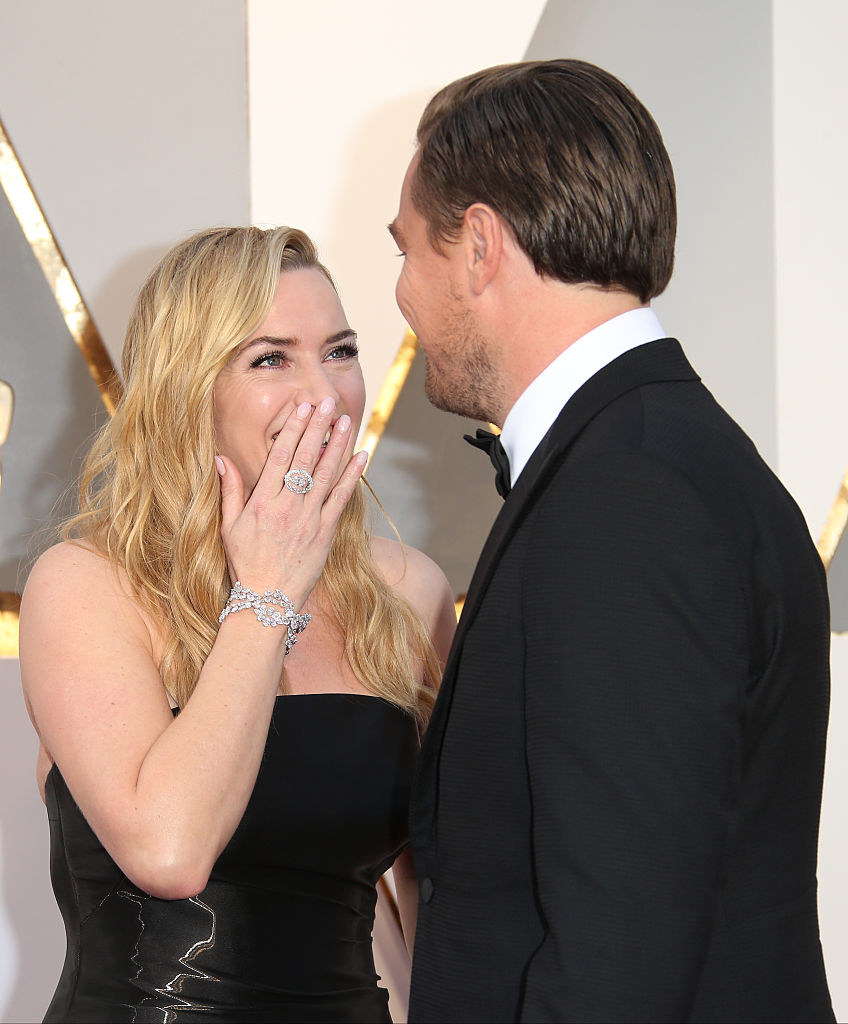 Kate smiling at Leo with her hand over her mouth