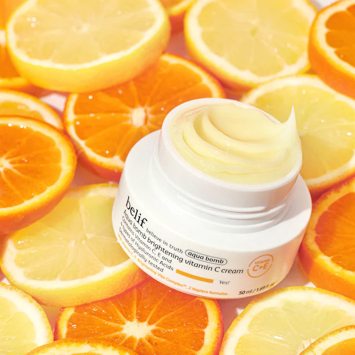 An open container of face cream on a layer of sliced oranges