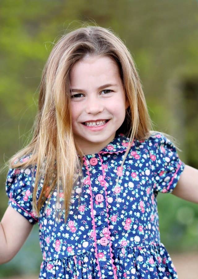 Charlotte smiling and wearing a short-sleeved, flower-print dress