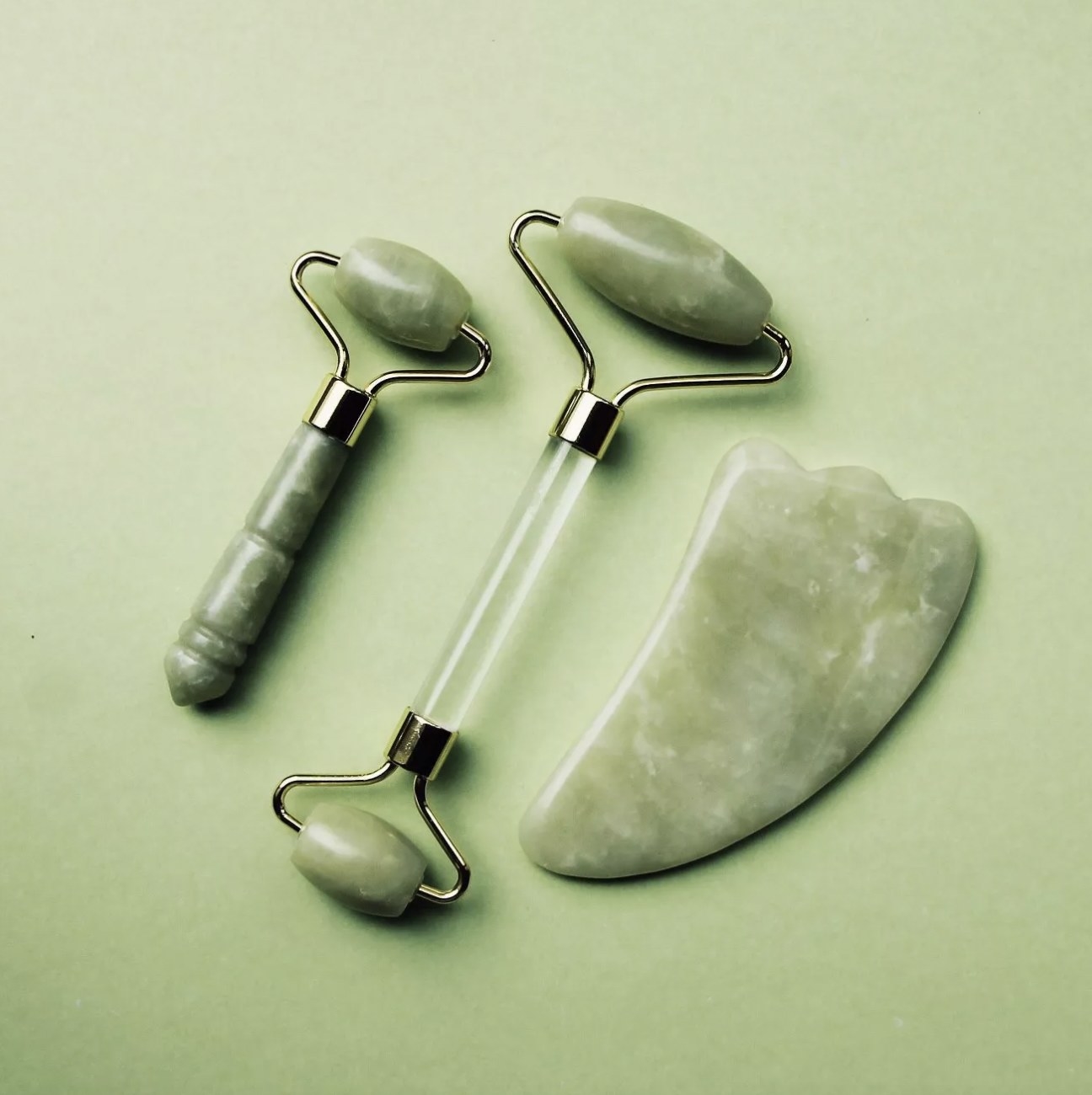 A jade roller,  a mini jade roller and a gua sha massaging tool