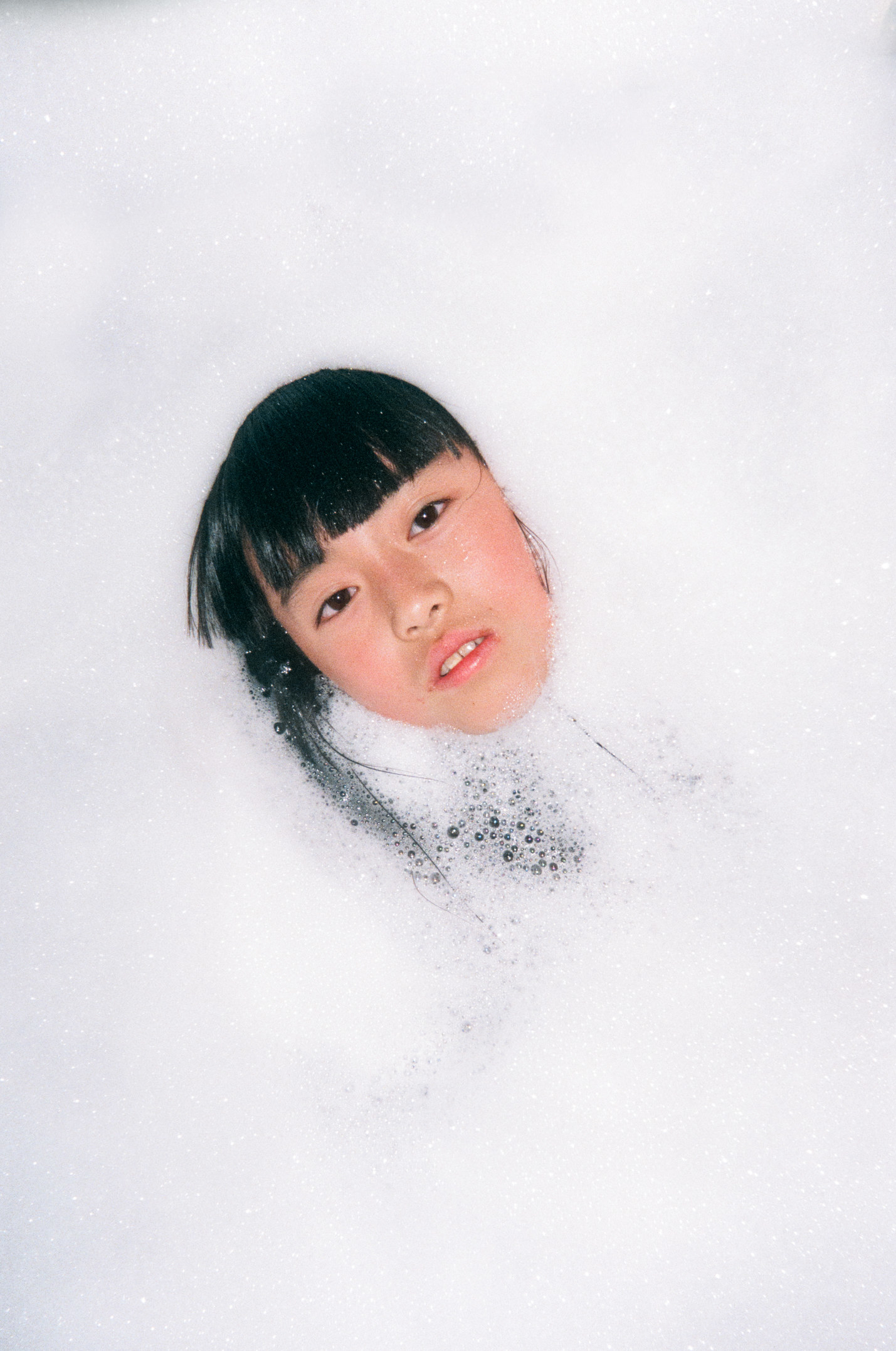 The photographer&#x27;s daughter surrounded by bubbles in the bath