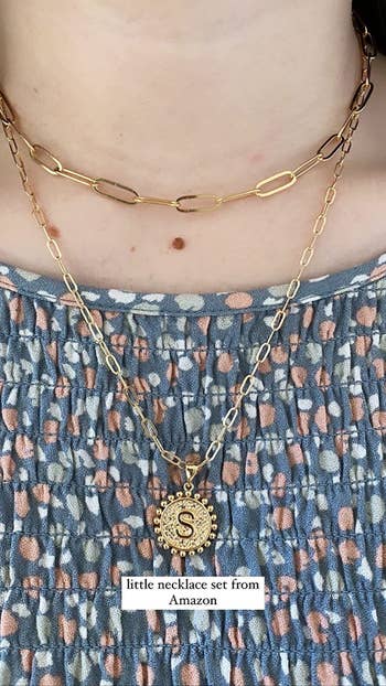 a reviewer wearing the necklace set with the initial 