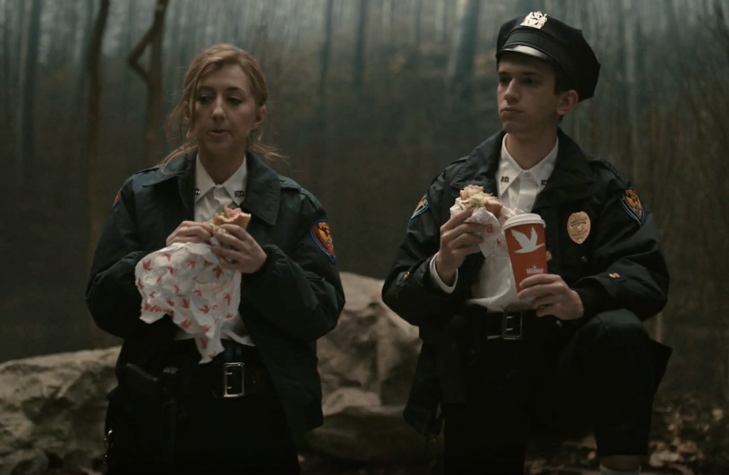 SNL cast members in cop uniform with Wawa sandwiches and coffee