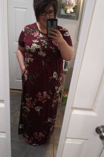 A reviewer wearing the short-sleeve dress in burgundy floral print
