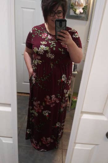 A reviewer wearing the short-sleeve dress in burgundy floral print