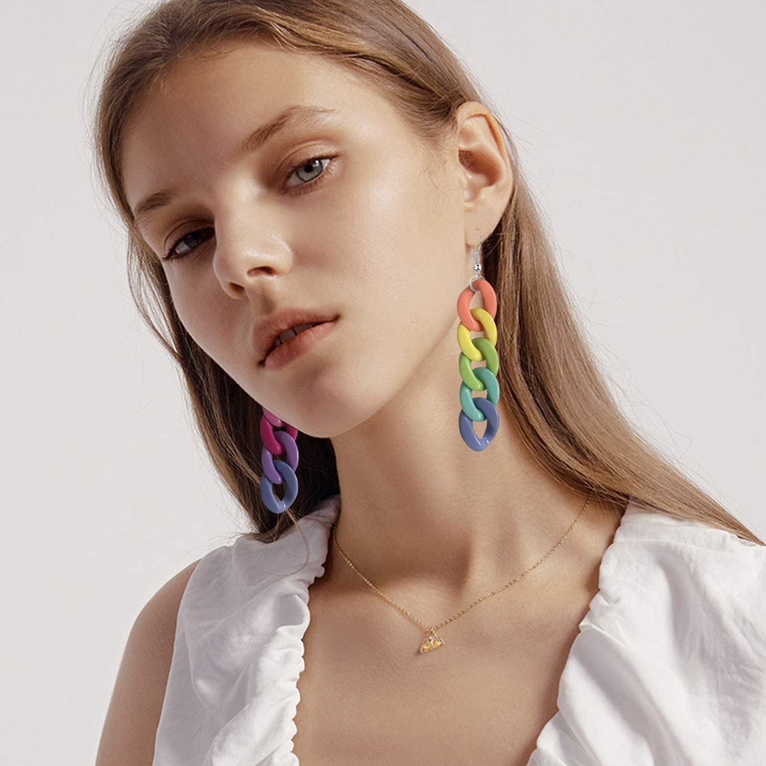 a model wearing the rainbow-colored pendant earrings