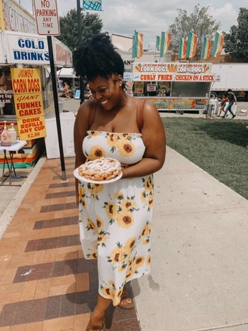 reviewer wears stretchy strapless top and midi skirt with yellow flowers 