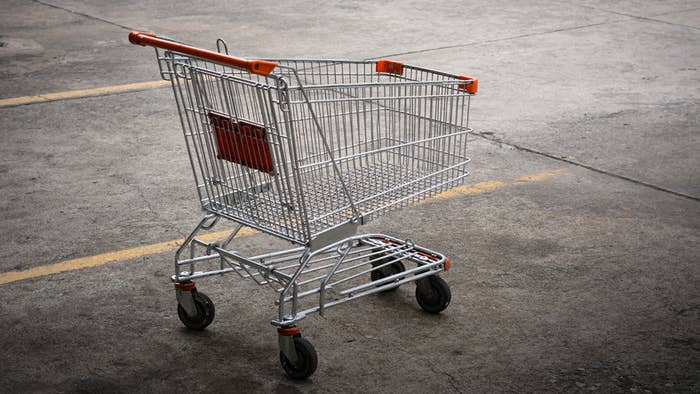 A lone abandoned shopping cart in a parking lot