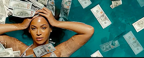 Beyoncé laying in a pool of money