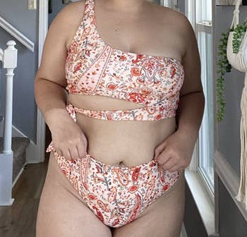 reviewer wearing the red paisley swimsuit