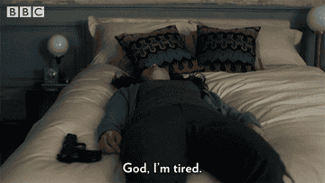 gif of someone laying on a bed on their back, lifeless that reads God I&#x27;m tired