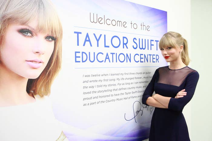 Taylor stands in front of a sign that says welcome to the Taylor Swift education center