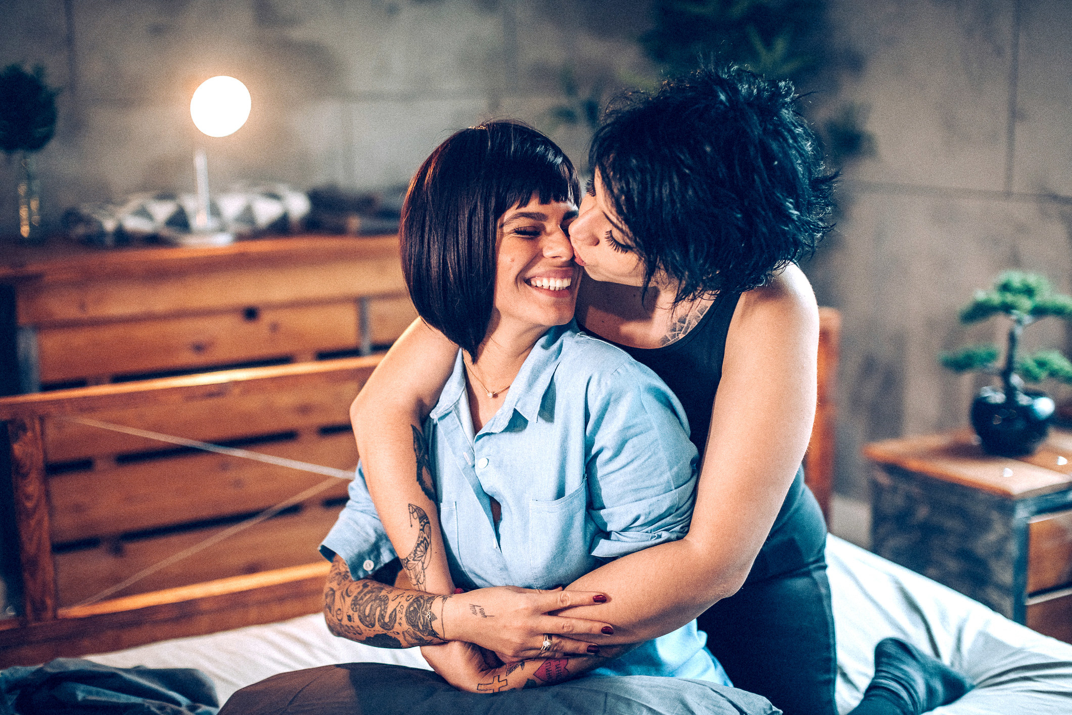 Two women kissing in bed